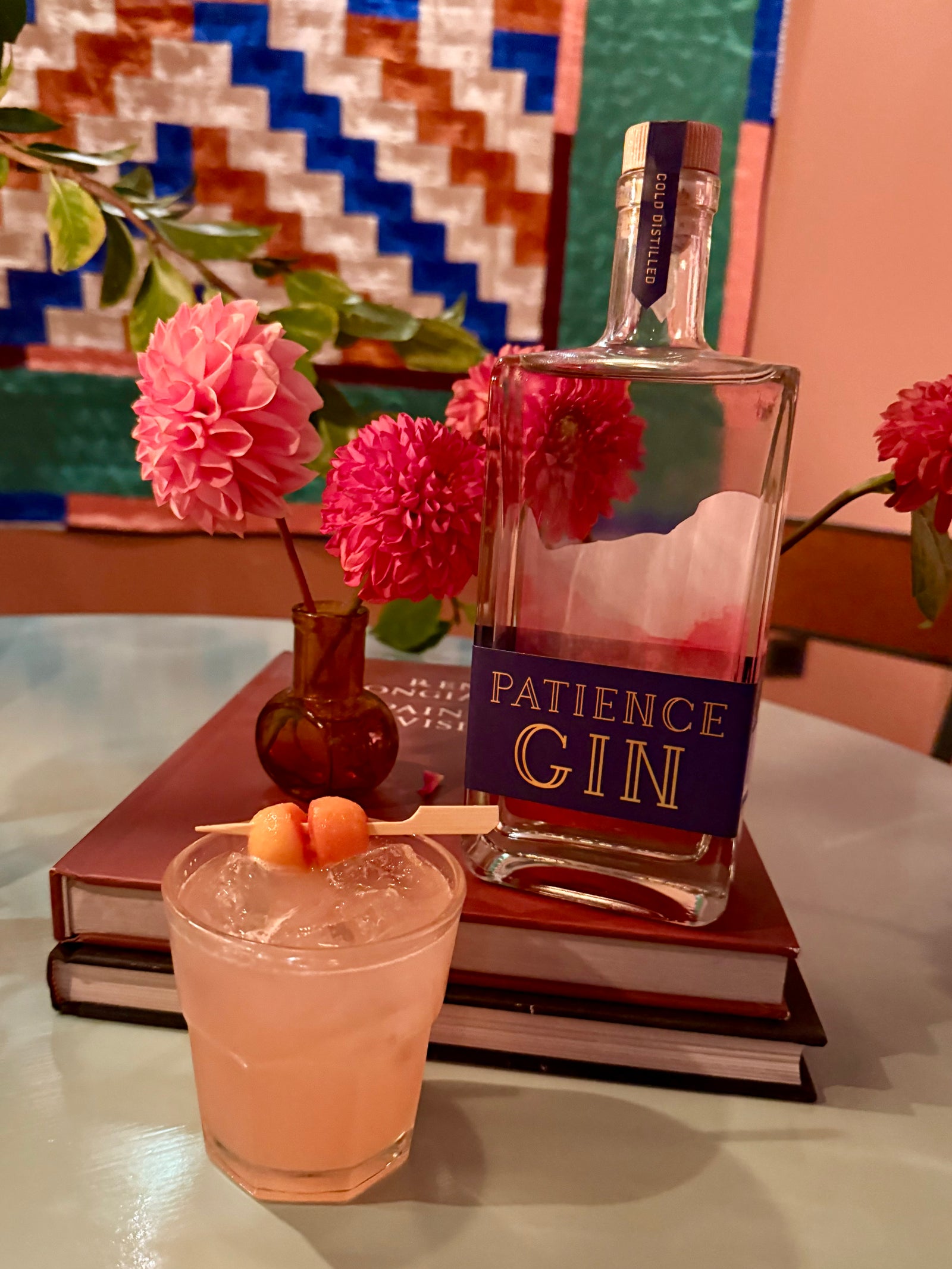 Patience Autumn Gin bottle with a cocktail and flowers on a table