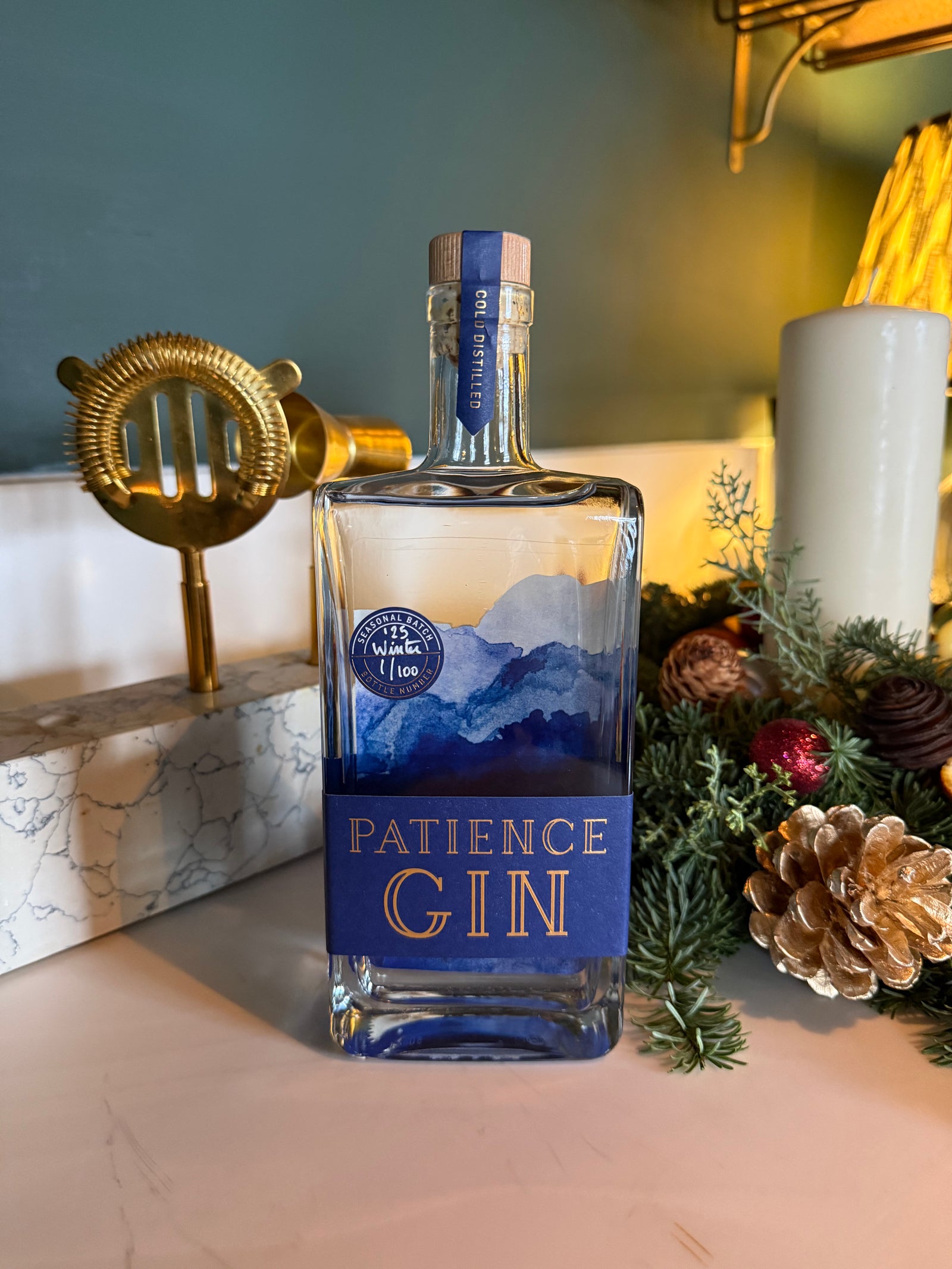 Bottle of Patience Winter Gin with decorative elements on a surface