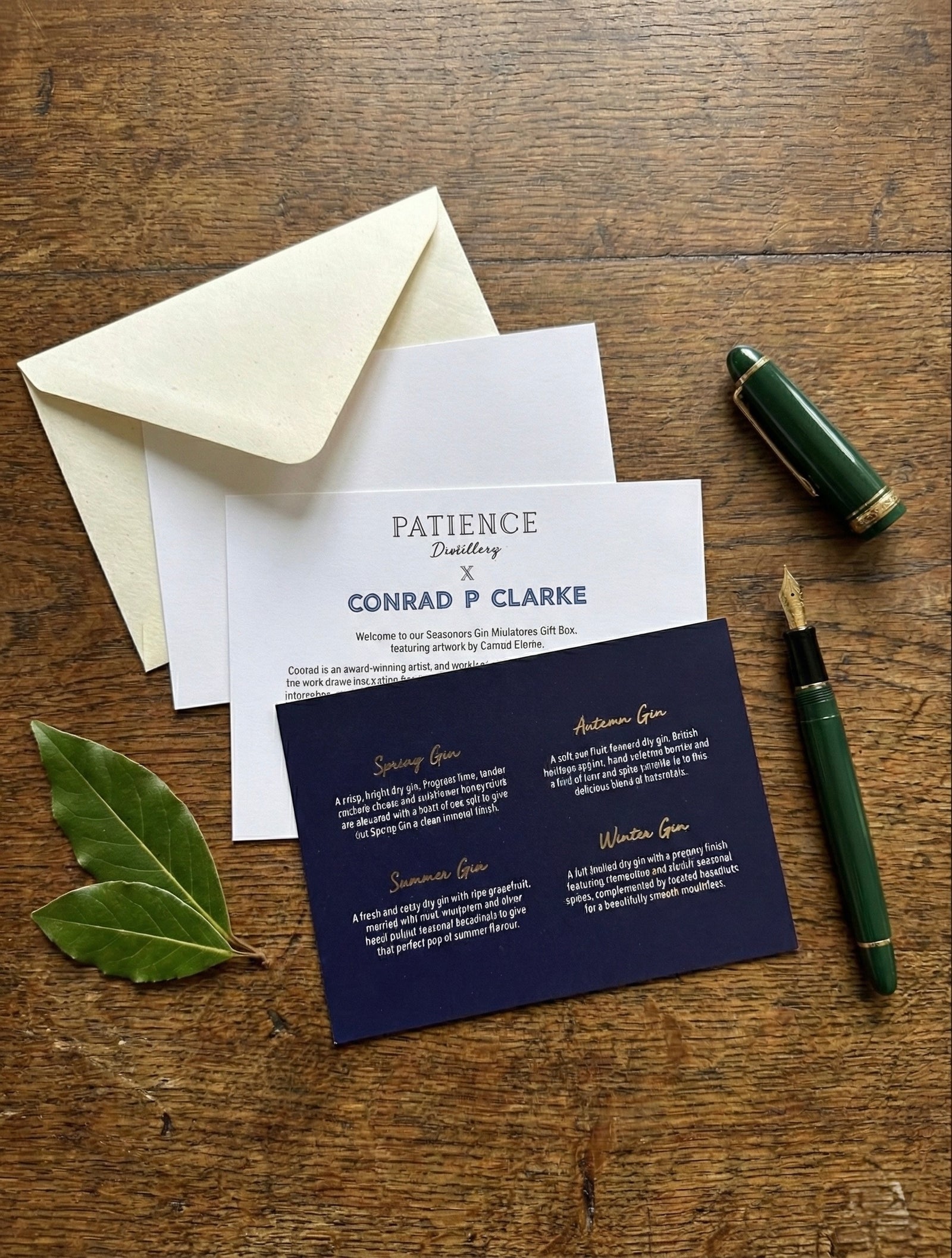 Stationery set for Patience Distillery with a letter, card, and pen on a wooden surface