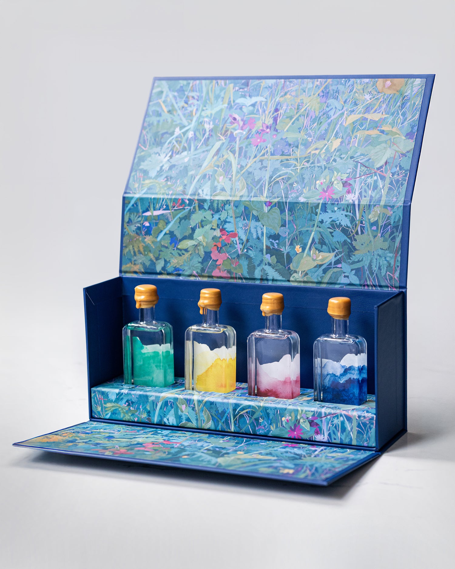 Patience Distillery gift box set. Set of four small bottles with colorful contents in a decorative box with floral design