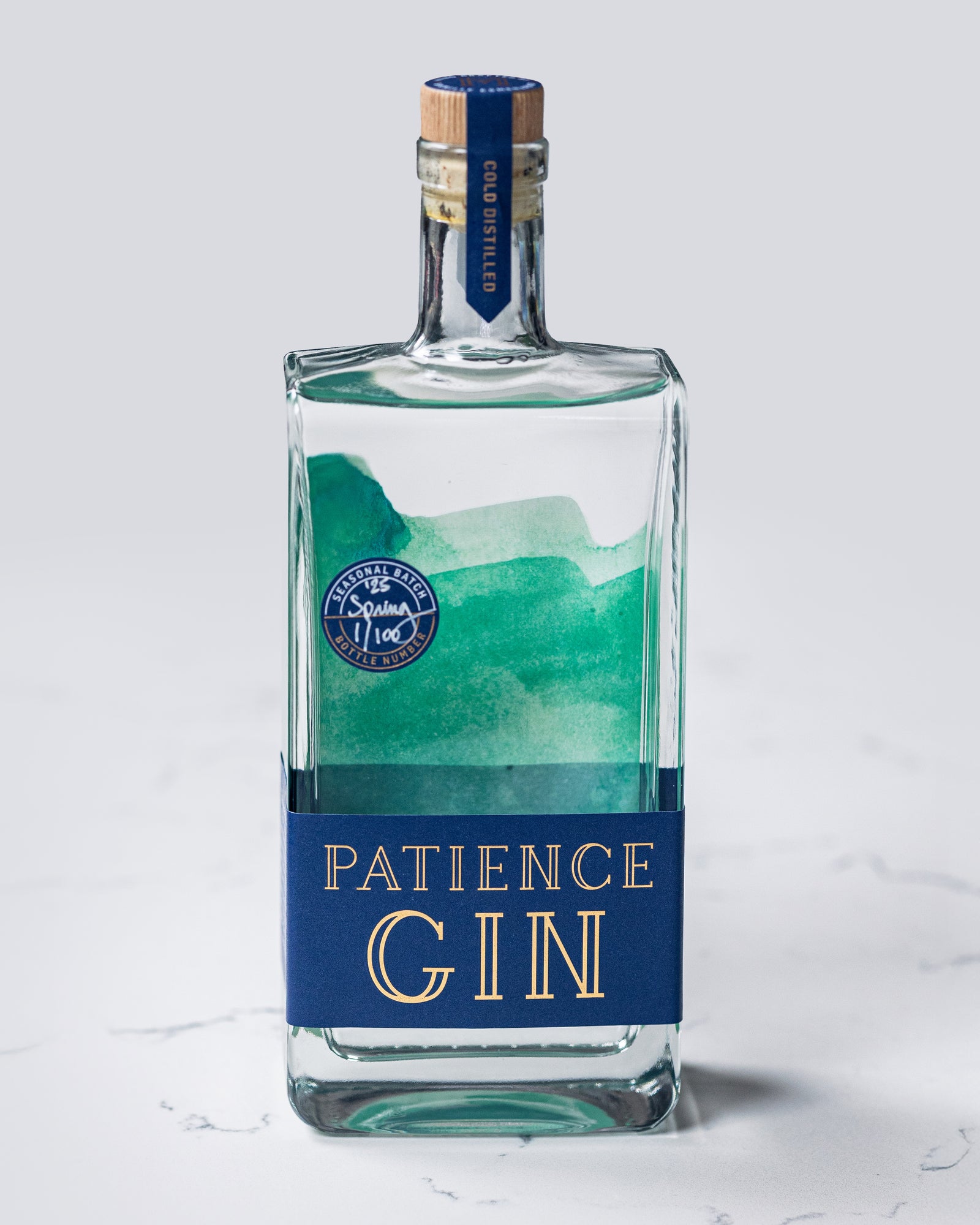 Bottle of Patience Spring Gin on a light gray background