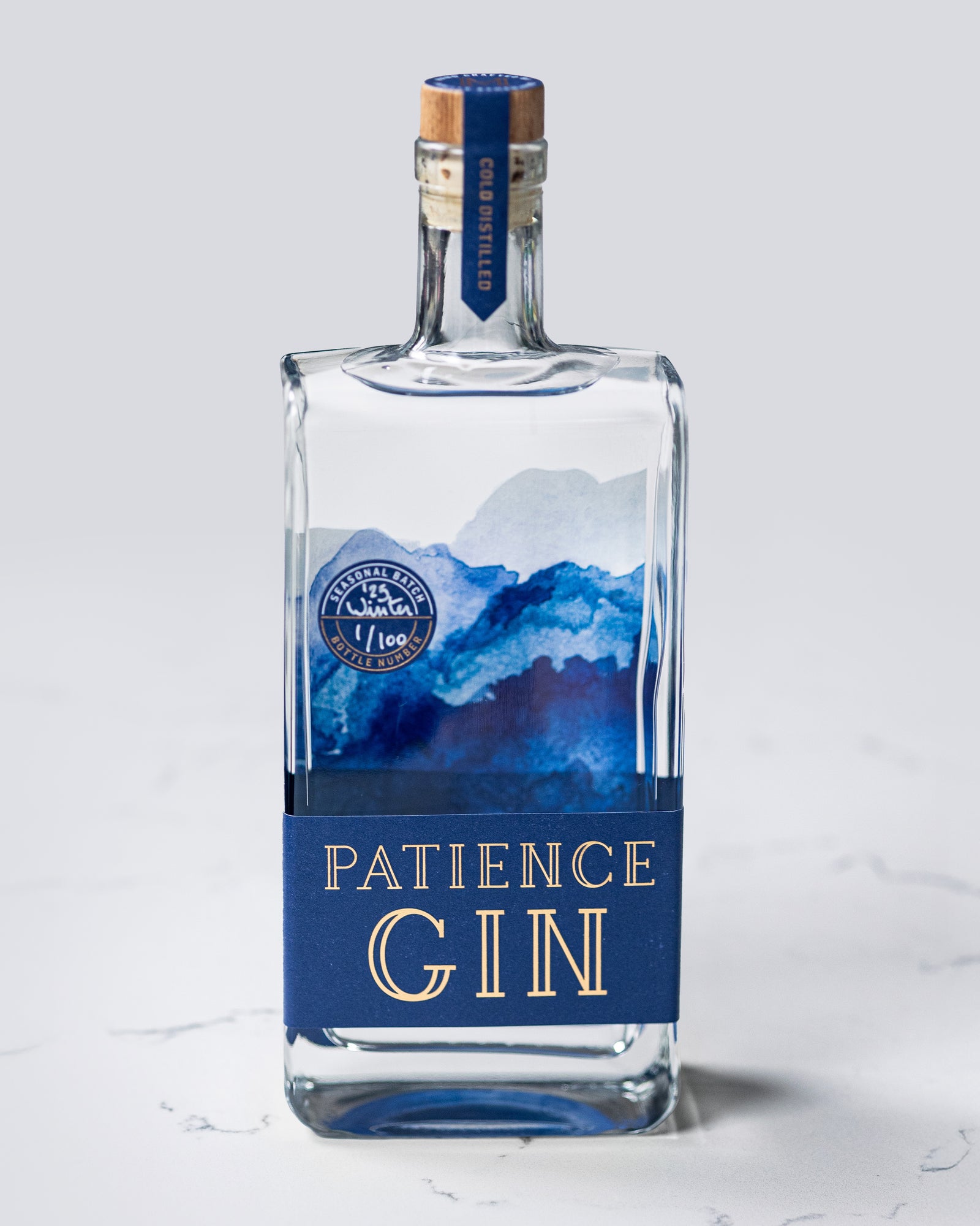 Bottle of Patience Winter Gin on a light gray background